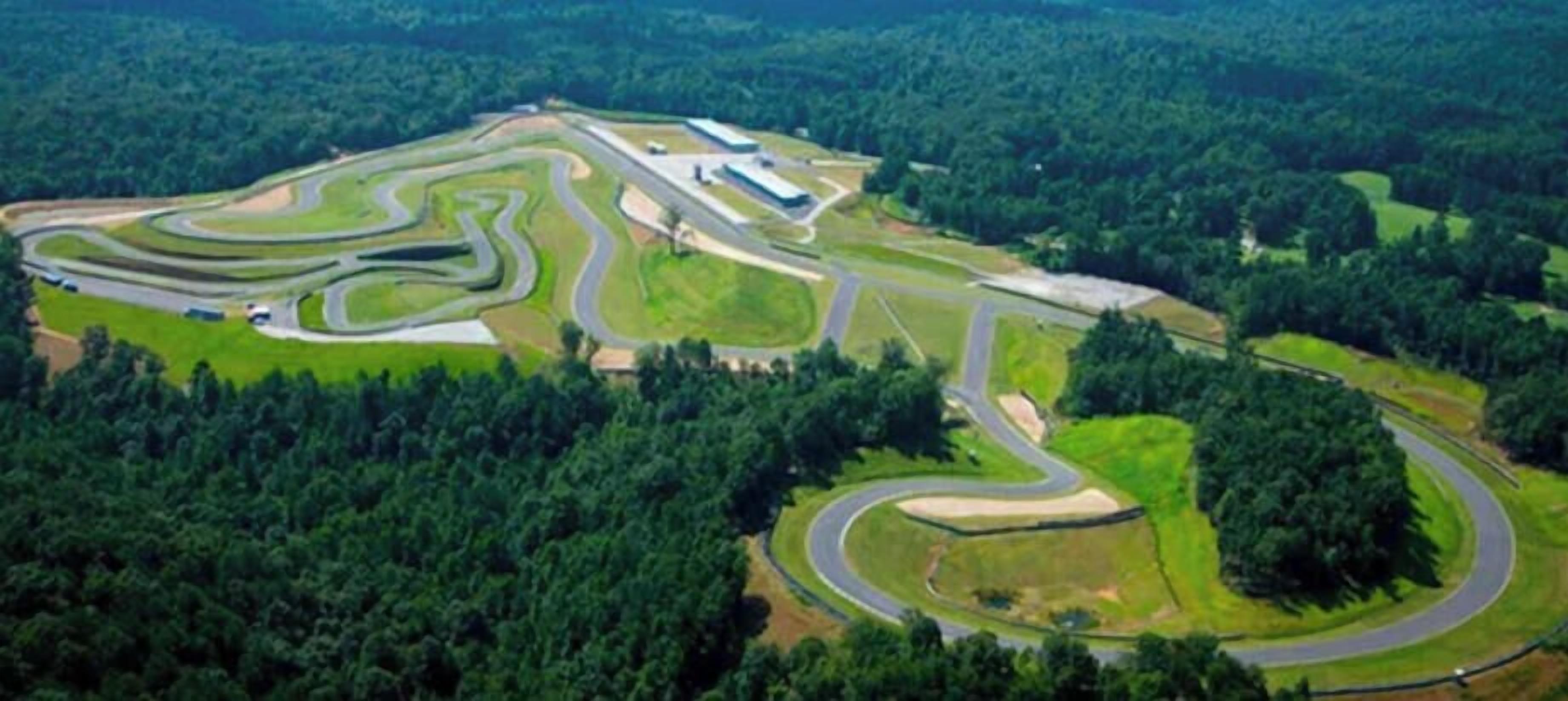 Luchtbeeld van een racecircuit, omgeven door dicht bos.