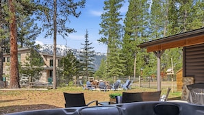 A hot tub with chairs, a wooden deck, and a mountain view. - Beach Access + Hot Tub | Near Tamarack & McCall (Donnelly)
