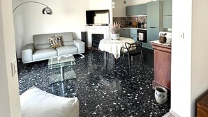 Un salon moderne avec un canapé, une table basse et un coin repas avec des chaises.