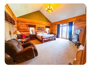 A log cabin room with a bed, a sofa, a desk, and a dresser. - Spacious 5-bedroom cabin in charming Bellaire on Golf Course (Bellaire)