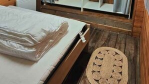 A bedroom with a bed, a wardrobe, and a small stool. - MOBIL HOME MARMOTTES 6 PERS (Besse-et-Saint-Anastaise)
