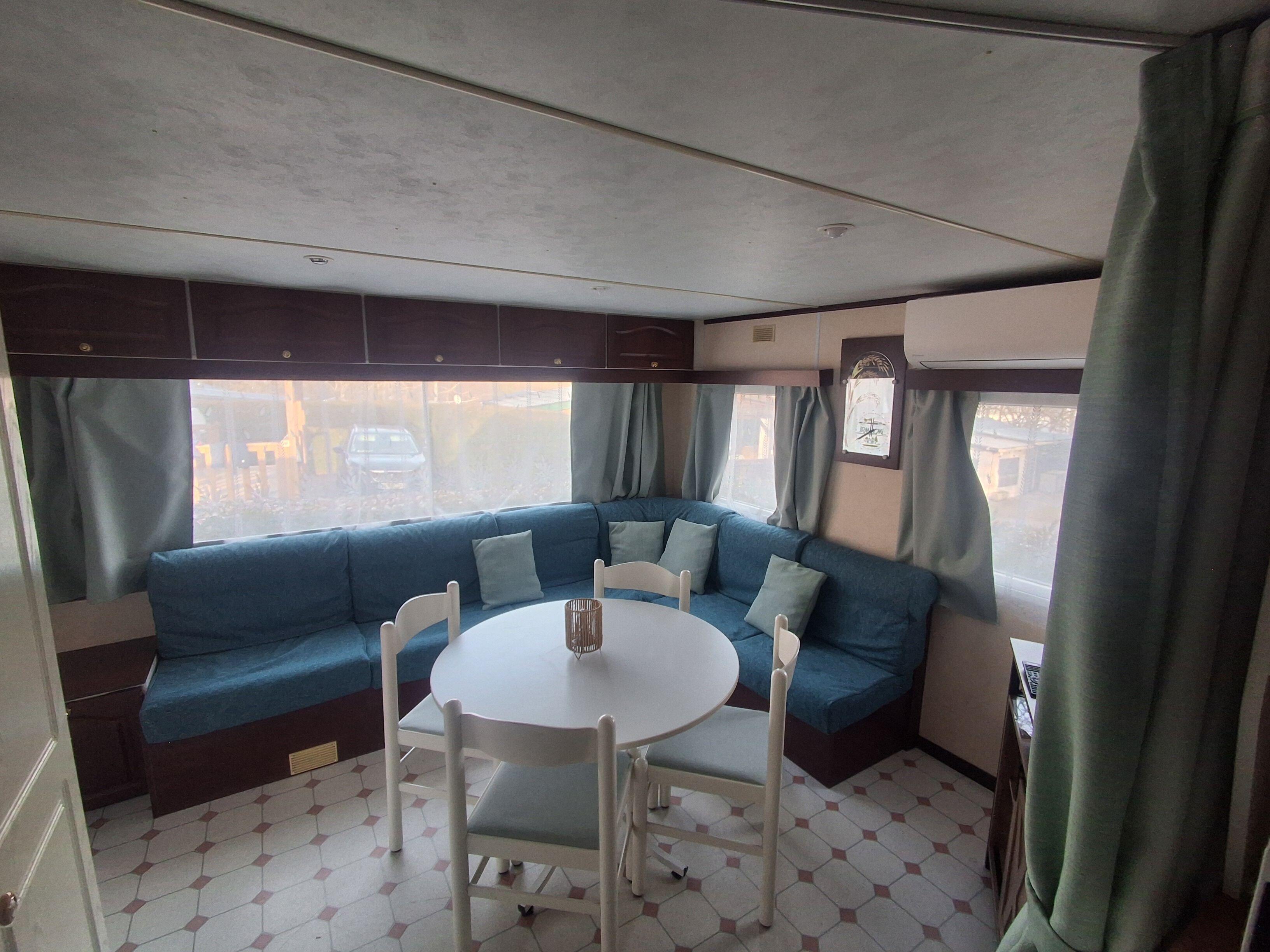 A compact living space with a blue sofa, a round table, and chairs.
