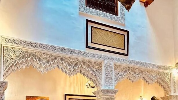 A traditional Moroccan interior with ornate arches, patterned cushions, and a tiled floor. - Patrimoine de Fes  (Fès)