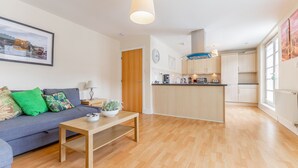Ein modernes Apartment mit Wohnzimmer, Küche und Essbereich.