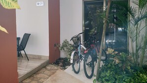Una habitación con una puerta marcada 'B-01', una bicicleta y una silla.
