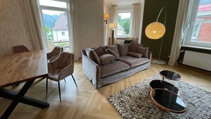 Un salon moderne avec une table à manger en bois, un canapé marron et une table basse ronde.