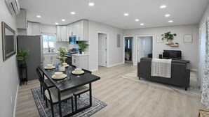 Een modern appartement met een eethoek, keuken, woonkamer en een klein balkon.