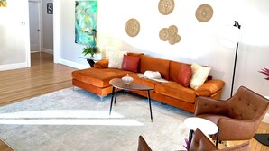 Una sala de estar moderna con un sofá modular, una mesa de centro y un sillón de cuero marrón.