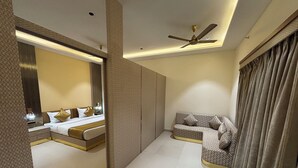 Une chambre d’hôtel moderne équipée d’un lit, d’un canapé et d’un ventilateur de plafond.