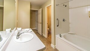 Een badkamer met een bad, wastafel en toilet.