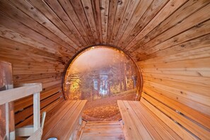 A wooden tunnel with benches and a view of a forest.