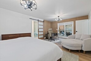 Une chambre à coucher avec un lit, un bureau, une chaise et un canapé.