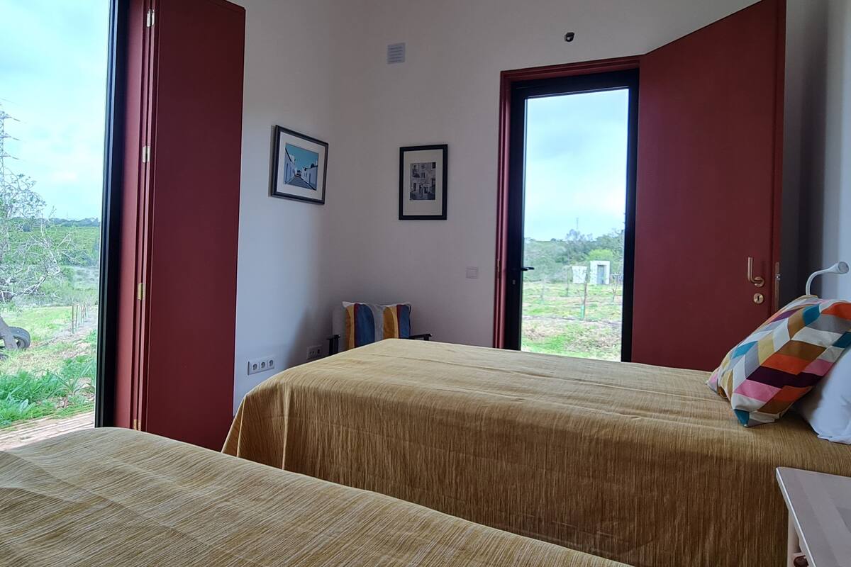 Een slaapkamer met twee bedden, een raam en een deur.