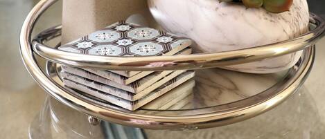 A glass table with a decorative elephant figurine, a succulent plant, and a stack of books.