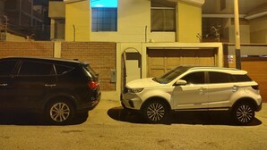 A modern two-story house with a garage, a driveway, and two parked cars. - APARTMENT NEAR LOS INCAS GOLF COURSE AND THE U.S. EMBASSY LIMA - PERU (Lima)