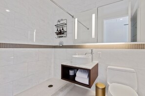 Een haardroger, handdoeken, zeep, toiletpapier
