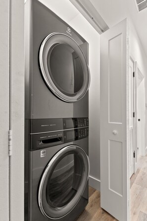 A modern, built-in washer and dryer unit with a control panel and a door. - Cherry St Chateau | Immaculate Home In Old West Tampa, 5 Min to Ray J (Tampa)