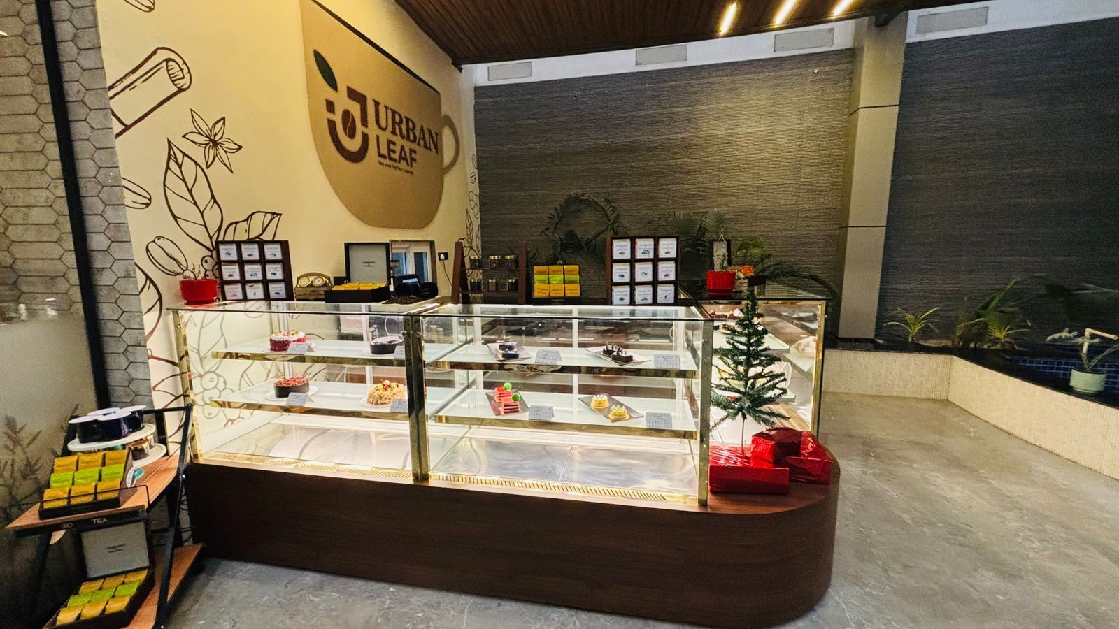 A bakery display with various baked goods and a small Christmas tree.