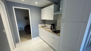 Een moderne keuken met witte kastjes, een aanrecht en een koffiezetapparaat.