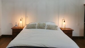 A bedroom with a bed, two bedside tables, and two wall-mounted lamps. - Private Pool With Huge Terrace Garden (Celorico de Basto)