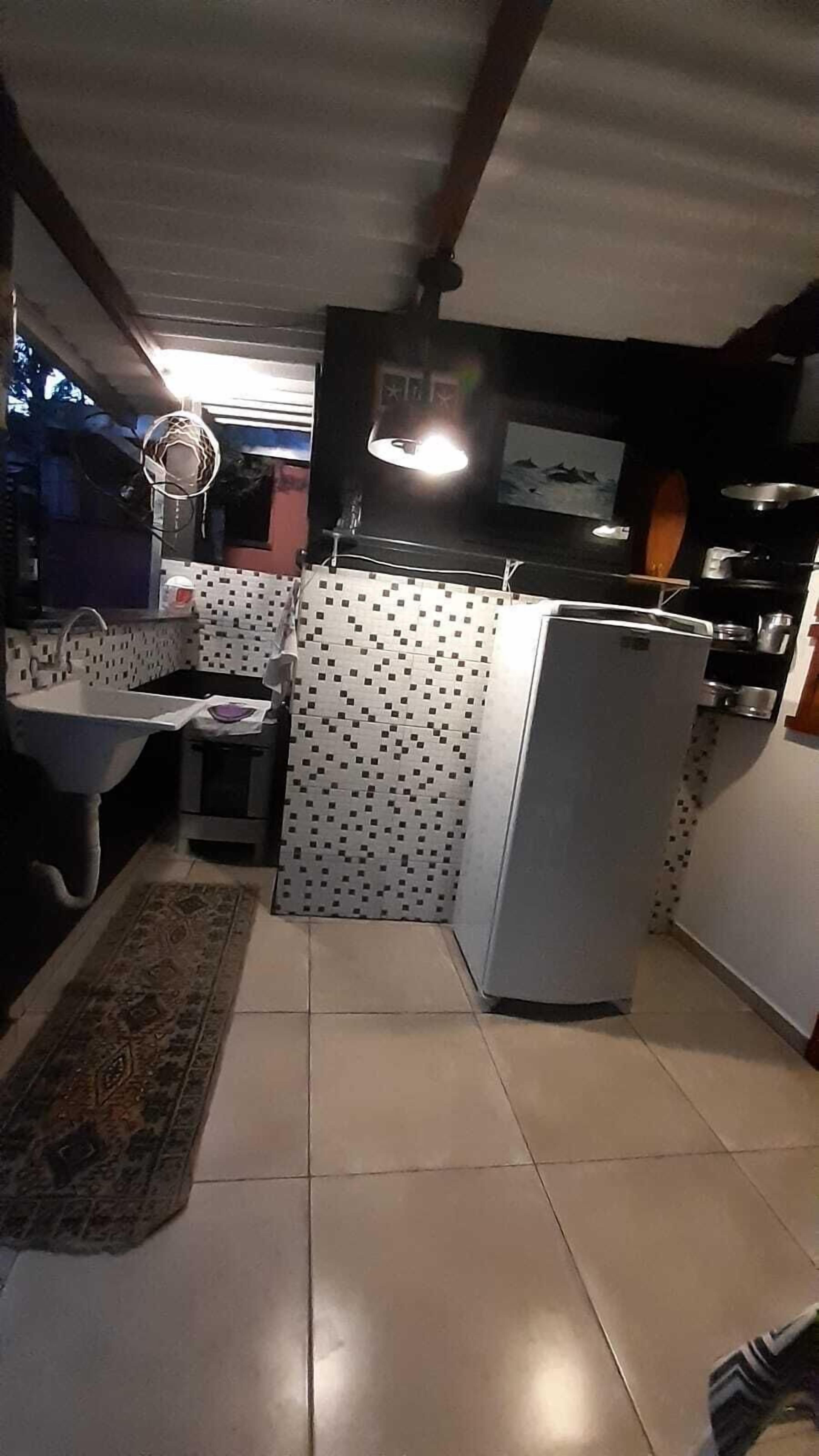 Une cuisine de taille réduite, équipée d’un réfrigérateur, d’un évier et d’une petite table.