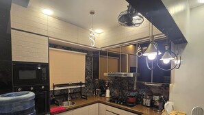 A modern kitchen with a granite countertop, stainless steel appliances, and a water dispenser. - Karachi Beach Residency (Karachi)