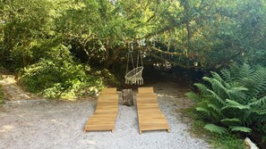 A wooden deck with a hanging chair and a swing, surrounded by dense greenery. - L'Autre Paradis, Natural Pools, Beaches, Enchanted Garden, Sauna (Poligny)