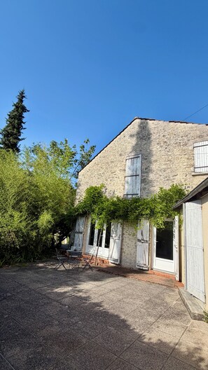 A stone building with a gravel courtyard, wooden shutters, and a tree. - L'Autre Paradis, Natural Pools, Beaches, Enchanted Garden, Sauna (Poligny)