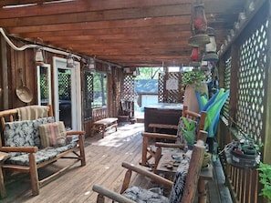 Une terrasse en bois avec des meubles d’extérieur, un jacuzzi et des plantes en pot.