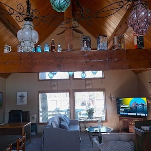 Un salon chaleureux avec un plafond en bois, un téléviseur et un canapé.