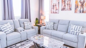A modern living room with two grey sofas, a marble coffee table, and three abstract paintings on the wall. - Family-Friendly Free Parking, Drinks & Snacks all complementary (Memphis)