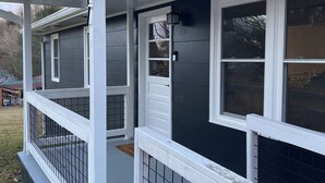 Ein Haus mit Veranda, Tür und Fenster.
