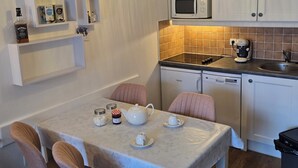A compact kitchen with white cabinets, a microwave, a coffee maker, and a dining table with chairs. - Apartment with kitchenette in the mountains of Valmeinier  (Valmeinier)