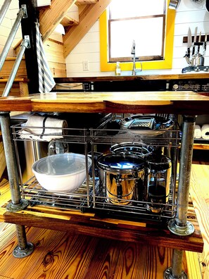 A kitchen with a built-in stove, a sink, and wooden cabinets.