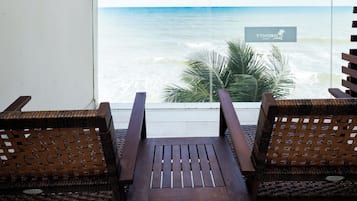 Ein Balkon mit zwei Holzstühlen und Blick auf das Meer.
