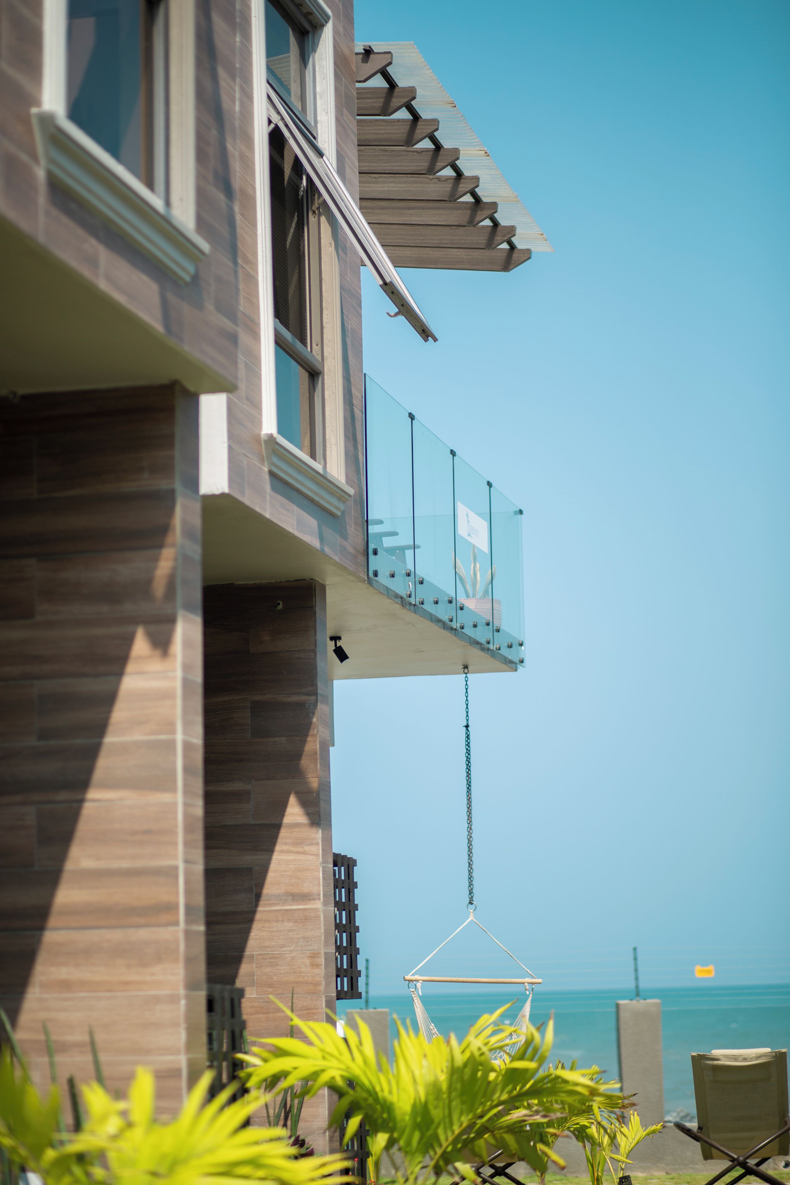 Ein modernes Gebäude mit einem Balkon mit Blick auf einen Strand.