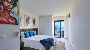 Um quarto moderno com uma cama, obras de arte e vista para o exterior.