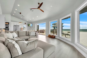 An elevated coastal living space where floor-to-ceiling windows bring the beauty of the Gulf and North Captiva indoors