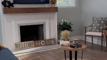 Een smart-tv, een open haard en boeken