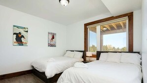 A bedroom with two beds, a large window, and posters on the wall. - Grand 8-Bedroom Retreat, 7 Baths - Perfect Chalet (The Blue Mountains)