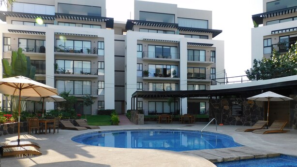 Ein modernes Hotel mit Schwimmbad, Außenbereich und einer Steinfassade.