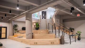 Un'ampia hall con una scalinata centrale, una reception e zone relax.