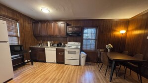 A compact kitchen with wooden cabinets, a microwave, a dishwasher, and a stove. - Prime 1BR: Minutes to Toledo, Sylvania & MI (Toledo)