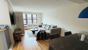 Un salon moderne comprenant un canapé, une table basse et un coin repas avec une table et des chaises.