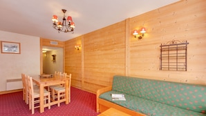 A wooden interior with a dining table, chairs, a sofa, and a bench. - R Sidence Le Cabourg St4n (Les Deux Alpes)