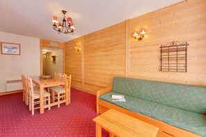 Ein Holzinterieur mit Esstisch, Stühlen, einer Couch und einer Bank.
