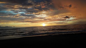 Ein Sonnenuntergang über dem Meer mit Wolken am Himmel.