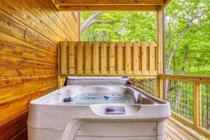 A hot tub in a wooden cabin with a view of trees. - Mountain Views, Hot Tub, Game Room & Deck (Sevierville)