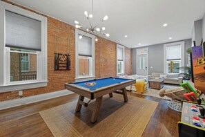 A modern living room with a pool table, a sofa, and a coffee table. - Over-the-Rhine, 4 Bedroom, Game Room, Grill & Patio (Cincinnati)