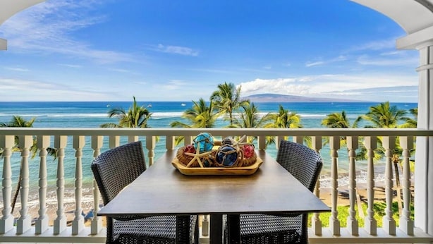 A balcony with a view of the ocean and palm trees. - Lahaina Shores Beachfront Condo with Panoramic Endless Ocean Views (Lahaina)